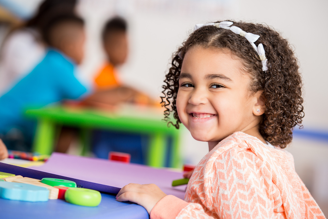 Excited little girl in daycare classroom