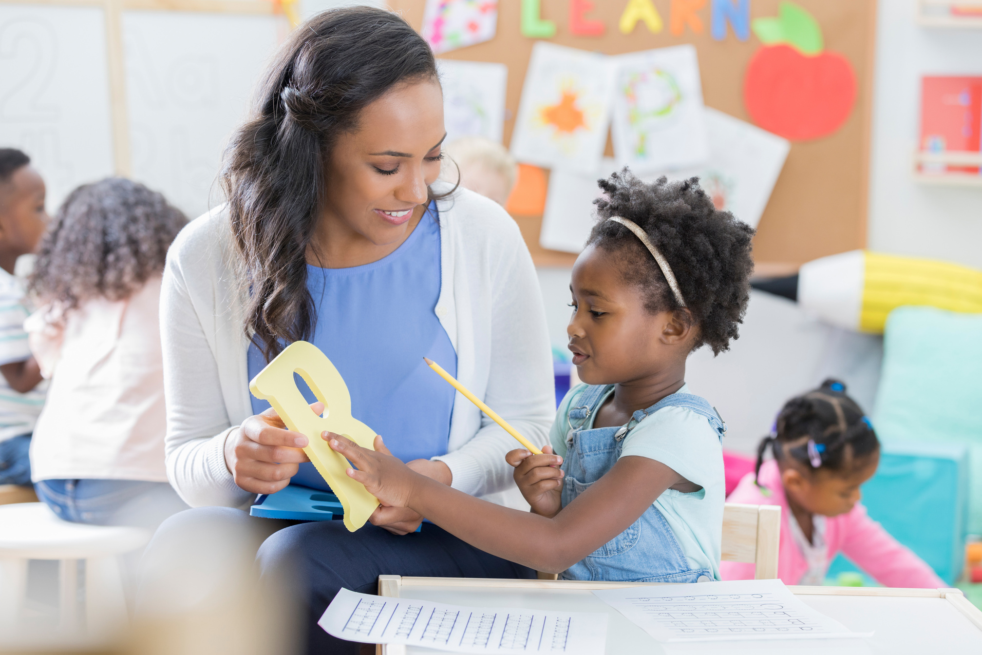 Daycare teacher teaches toddler the alphabet